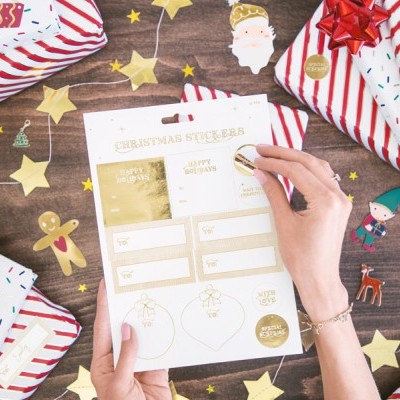 Papel para anotações de Natal rodeado por presentes e decorações festivas numa mesa