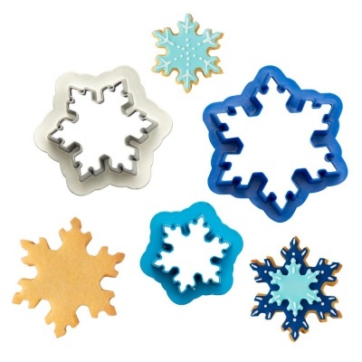 Cortadores floco de neve em plástico azul, branco e metal com biscoitos decorados