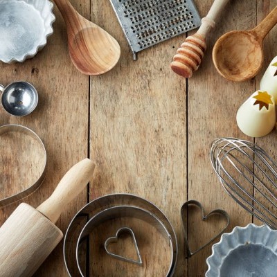 Utensílios de cozinha em madeira e metal sobre mesa de madeira