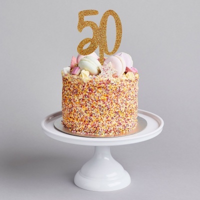 Bolo de aniversário com decoração colorida e topper 50 dourado