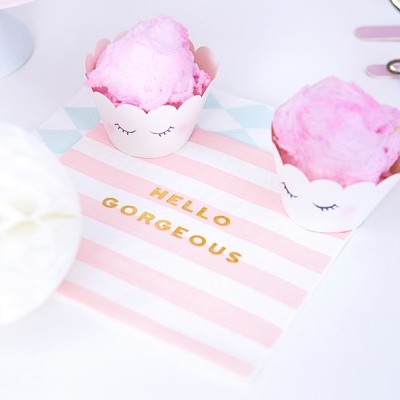 Dois cupcakes com cobertura rosa em forminhas brancas sobre guardanapo com texto HELLO GORGEOUS