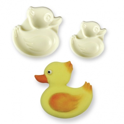 Três moldes em forma de pato, dois brancos e um amarelo com detalhes laranja em fundo branco