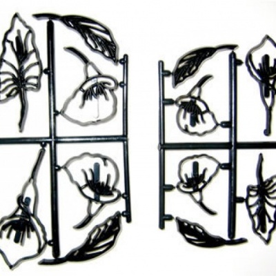 Dois moldes plásticos com peças de folhas e flores pretas