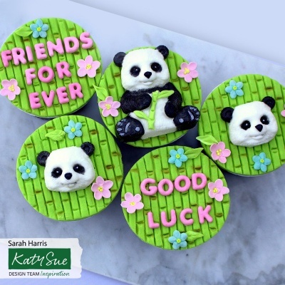 Cinco cupcakes decorados com temática de panda e texto em rosa sobre pasta verde