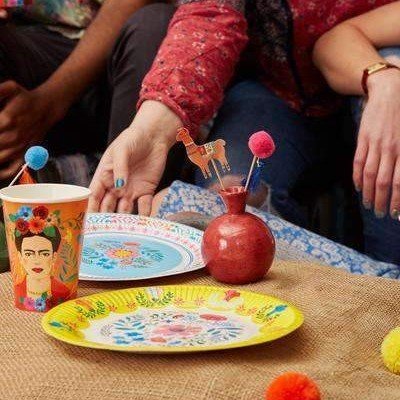 Artigos de mesa com design floral e imagem de Frida Kahlo em ambiente exterior