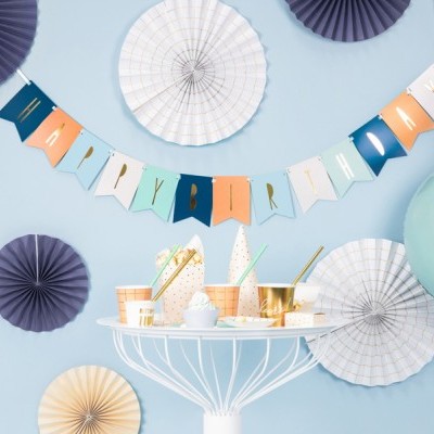 Decoração de festa com bandeirola 'HAPPY BIRTHDAY' e enfeites azuis e bege