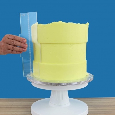 Bolo amarelo com textura cremosa em suporte branco e fundo azul.