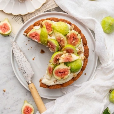 Tarte com figos frescos verdes e rosa sobre creme branco em prato cinza