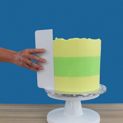 Bolo verde e amarelo em suporte branco com fundo azul