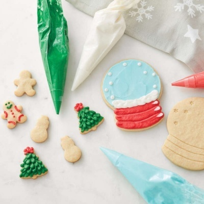 Biscoitos de Natal decorados com glacê colorido e sacos de confeitar coloridos