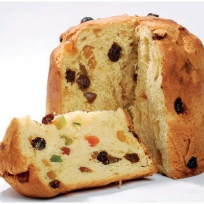 Panetone partido ao meio com uma fatia à frente mostrando frutos secos e cristalizados no interior