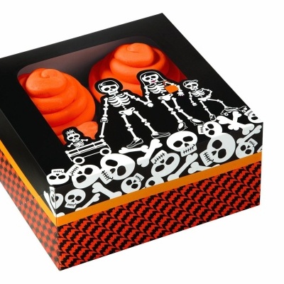 Caixa preta com esqueletos e caveiras brancas, com interior contendo dois objetos laranja em espiral