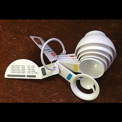 Colheres medidoras de plástico branco com etiquetas coloridas