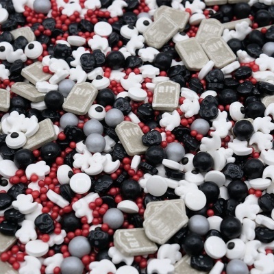 Confeitos decorativos Halloween com lápides, caveiras e ossos em várias cores.