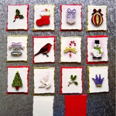 Biscoitos natalícios decorados com glacê branco e motivos coloridos