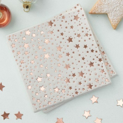 Guardanapo de papel branco com estrelas metálicas douradas e elementos de decoração festiva