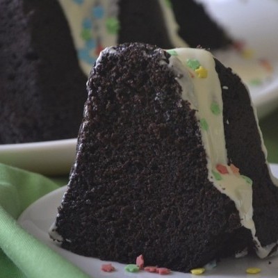 Fatias de bolo de chocolate com cobertura branca e granulados coloridos