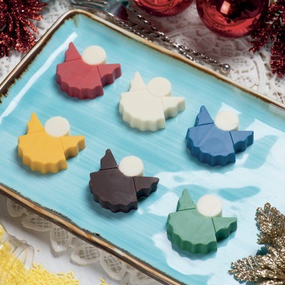 Seis anjos de cores variadas em tabuleiro azul com borda dourada, sobre toalha rendada branca com decorações natalícias