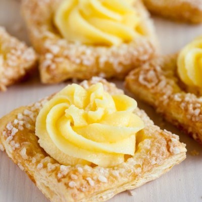 Pastel folhado com recheio cremoso amarelo e açúcar granulado