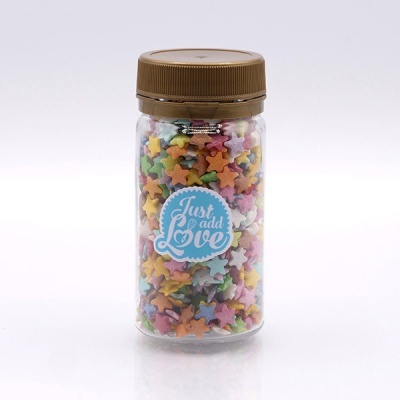 Frasco de plástico com confeitos em forma de estrelas coloridas e etiqueta 'Just add Love'