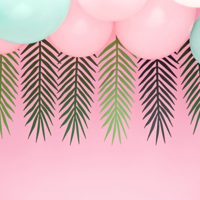 Decoração com balões cor-de-rosa e azul-claro e folhas verdes e pretas num fundo rosa