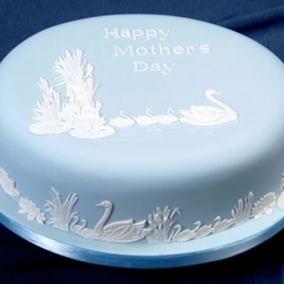 Bolo azul claro decorado com texto e figuras de cisnes em branco