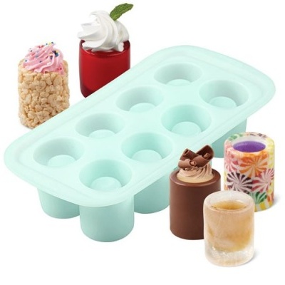 Forma de silicone azul clara com 10 cavidades arredondadas ao lado de cinco doces coloridos variados