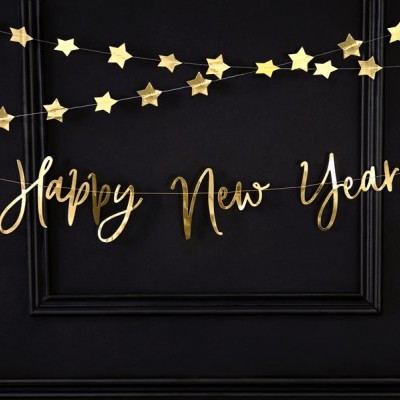 Decoração dourada de Ano Novo na parede preta com estrelas e texto