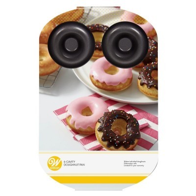 Forma preta para 6 donuts com embalagem Wilton e donuts decorados ao fundo