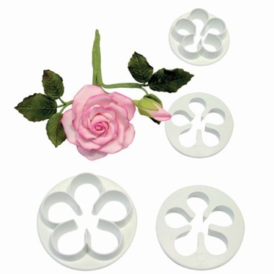Conjunto de cortadores brancos em vários tamanhos para pétalas de flores com rosa artificial rosa e folhas verdes.