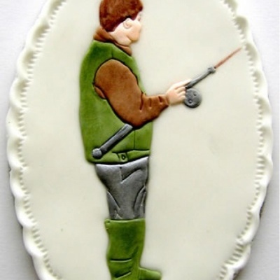 Bolo oval decorado com figura de pescador em glacê colorido