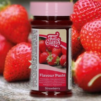 Frasco de pasta de sabor morango FunCakes com morangos frescos ao fundo