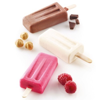 Três gelados popsicle em castanho, branco e rosa junto a avelãs, chocolate e amoras brilhantes