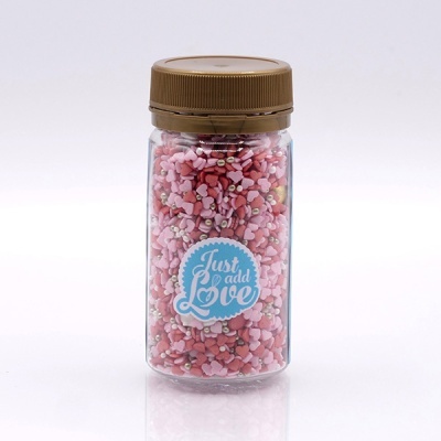 Frasco transparente com confeitos em forma de coração e etiqueta Just add Love