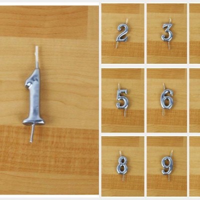 Velas numéricas metálicas prateadas sobre madeira clara