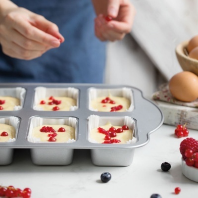 Tabuleiro com formas para bolos a serem decorados com frutos vermelhos