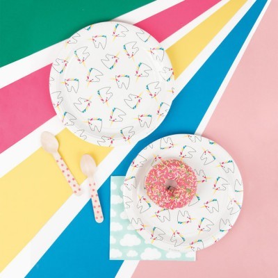 Pratos de papel com padrão de dentes e donut cor-de-rosa com granulados