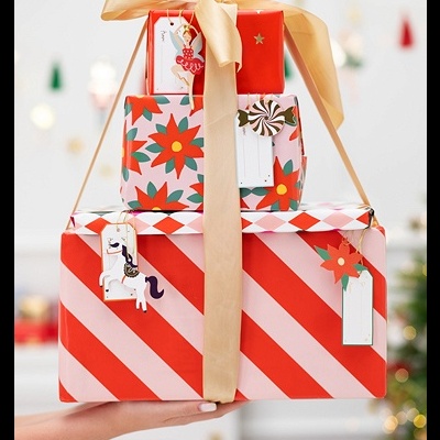 Três caixas de presente coloridas empilhadas com laço dourado