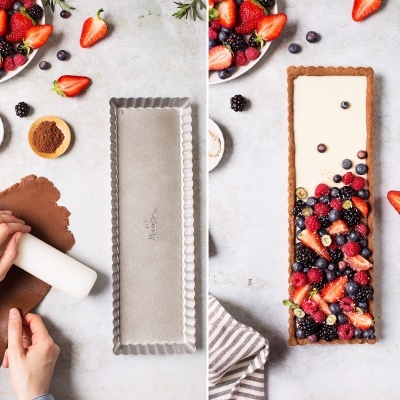 Tarte retangular com frutas vermelhas sendo preparada em duas fases, com massa e depois recheada com frutas.