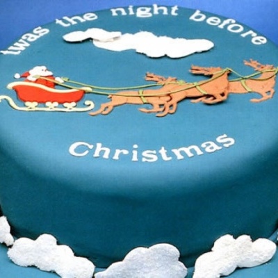 Bolo de Natal com decoração do Pai Natal, renas e nuvens em pasta azul