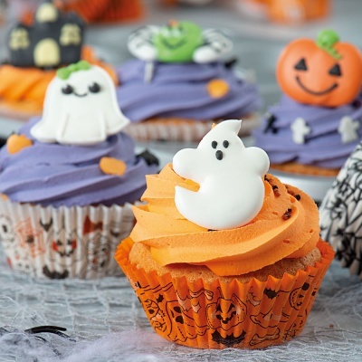 Cupcakes decorados de Halloween com cobertura laranja e roxa e decorações temáticas em açúcar.