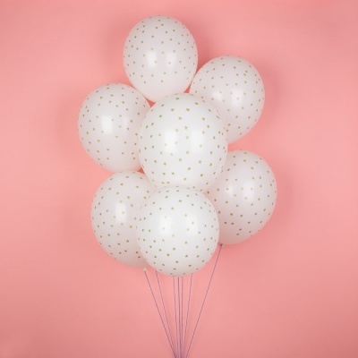 Balões brancos com estrelas douradas num fundo rosa