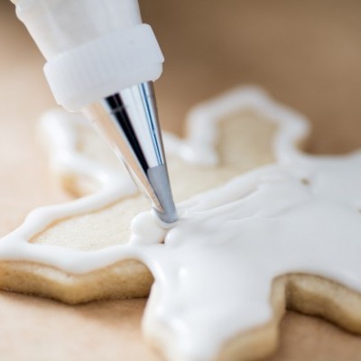 Açúcar biscoito floco de neve a ser decorado com glacê branco