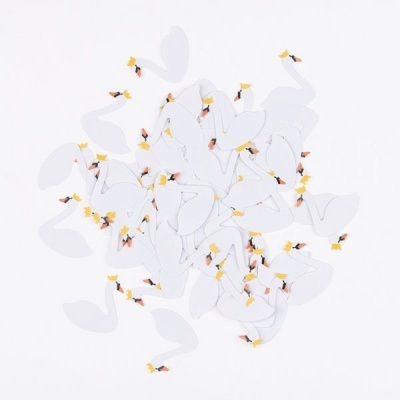 Várias figuras pequenas de cisnes brancos recortados com bicos laranja e cristas amarelas