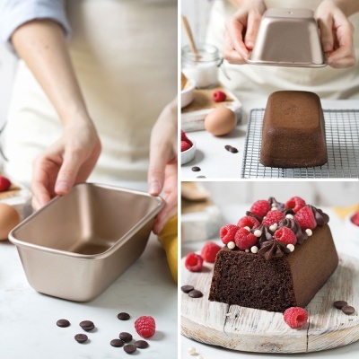 Forma de bolo retangular metálica bronze e bolo de chocolate decorado com framboesas