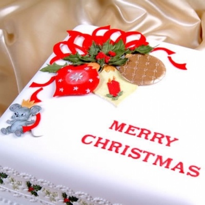 Bolo de Natal branco com decoração festiva e texto Merry Christmas