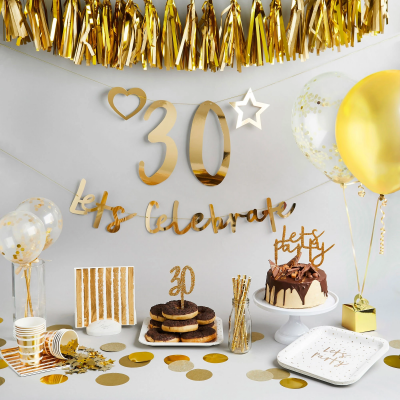 Decoração de festa dourada com balões, bolo, donuts, faixas e artigos descartáveis