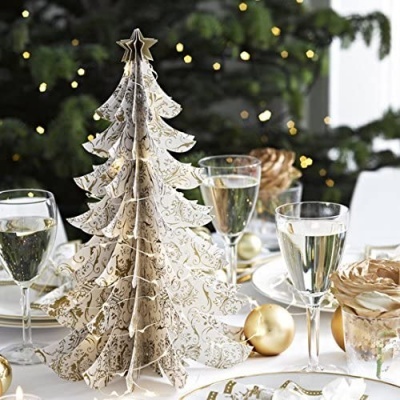 Árvore de Natal decorativa em papel branco com padrões dourados numa mesa de jantar decorada para Natal