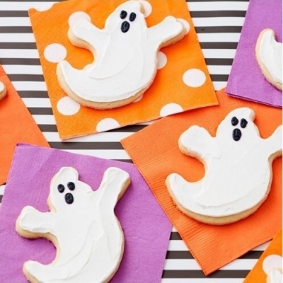 Biscoitos decorados em forma de fantasmas sobre guardanapos coloridos