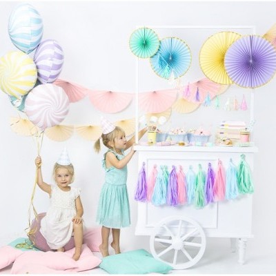 Carrinho de festa branco decorado com franjas coloridas e balões pastel com duas crianças